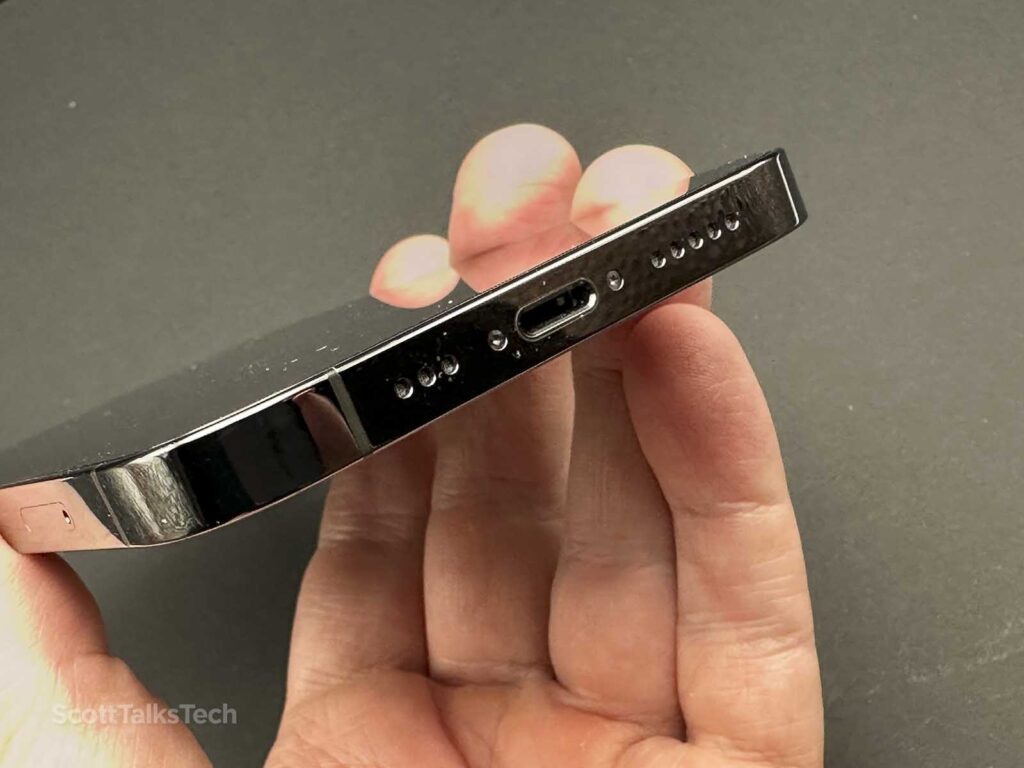 Space gray Apple iPhone 12 Pro bottom close-up showing speaker holes