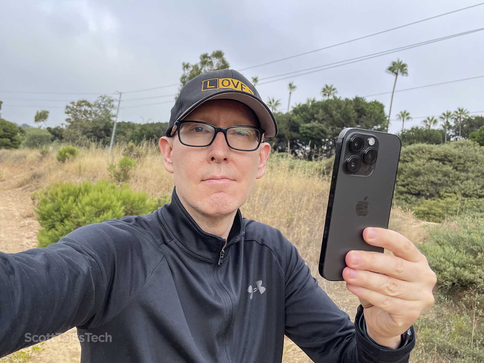 Scott holding up his space black apple iPhone 14 pro